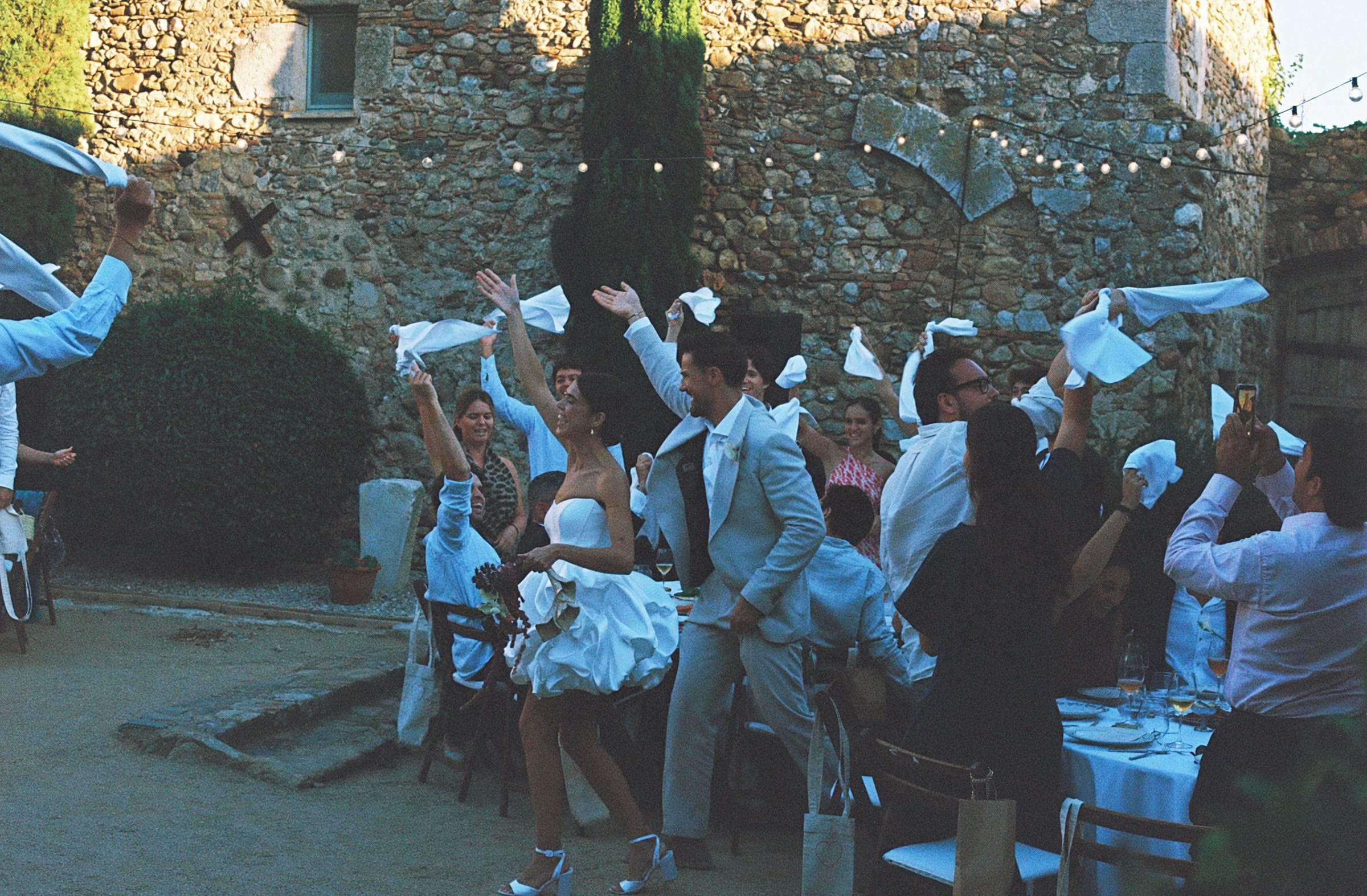 Invitados celebrando en un patio de piedra